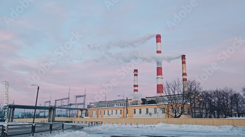 urban thermal power plant in the evening, a thermal power plant with cooling towers producing energy during Winter and cold months. Pink, purple clouds