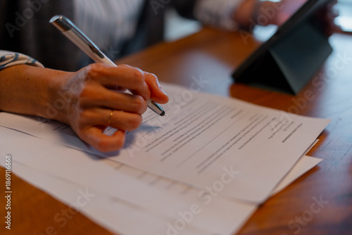 Person signing legal document finalizing business agreement

