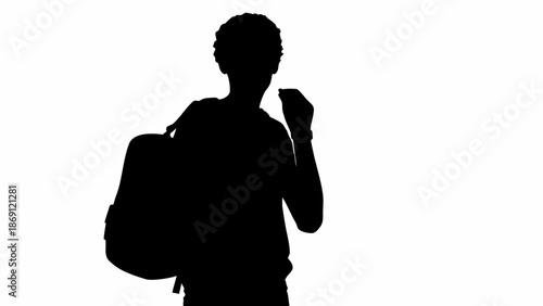 Silhouette of young man with backpack looking ahead confidently