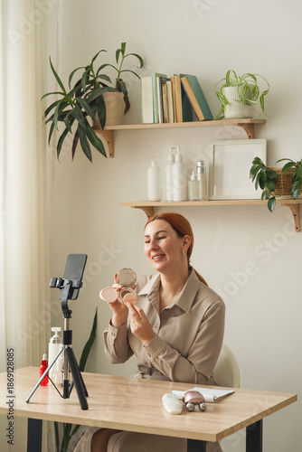 Woman vlogging skincare review for social media. A beautiful, well-groomed woman broadcasts online beauty lessons using skin care products