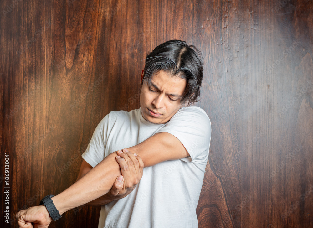 Fototapeta premium Man with elbow pain highlighted in red. Young man with elbow pain due to arthritis
