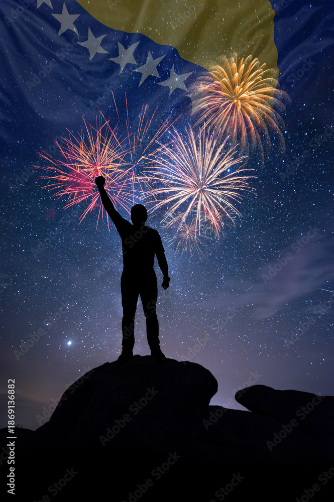 Fototapeta premium Man against background of a fireworks and national flag of Bosnia Herzegovina