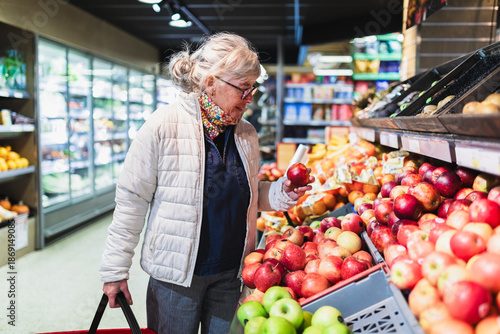 Senior Woman Selecting Fresh Apples in Grocery Store