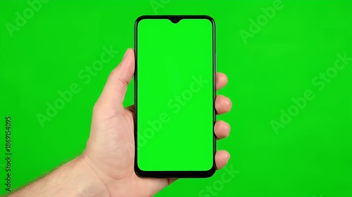 Hand Holding Vertical Smartphone With Green Screen On Green Background