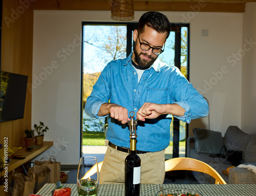 Man opens a bottle of wine at home