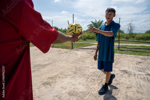 Two man playing traditional asian sport game sepak takraw. Male asian sepaktakraw player playing sepak takraw popular sports at outdoor court
