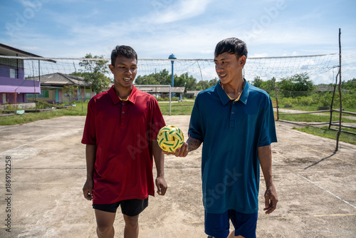 Two man playing traditional asian sport game sepak takraw. Male asian sepaktakraw player playing sepak takraw popular sports at outdoor court
