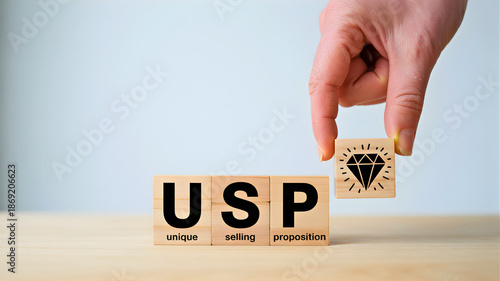 Unique Selling Proposition conceptualized with a hand placing the final piece, a diamond, into the USP blocks on a table