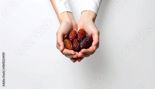 Hands holding dates on a white background