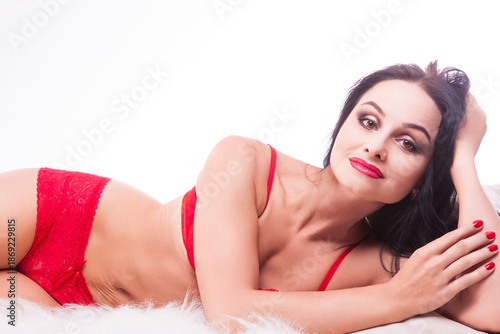 Positive Brunette Woman On Fur Blanket. Posing With Hands Touching Head