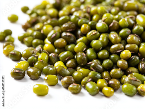 A close-up, high-angle view of a pile of raw, dried mung beans (Vigna radiata), also known as green gram, scattered on a plain white background. 