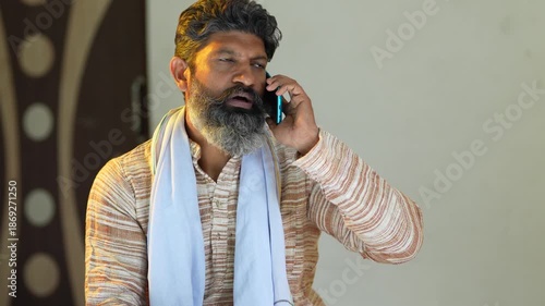 indian farmer talking on smartphone at home 