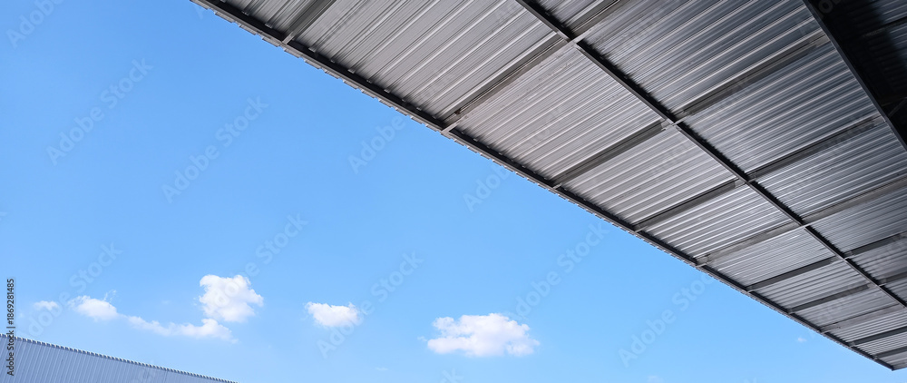 Fototapeta premium Metal sheet roof curve on blue sky. Modern construction, Metal ribbed arch span roof covering, Large building roof. not ai