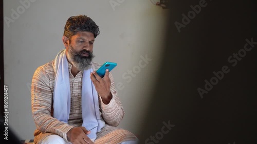 indian farmer using smartphone at home 
