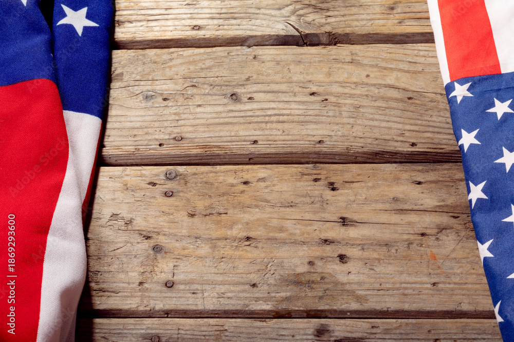 Fototapeta premium High angle view of usa flags with stars and stripes on wooden table with copy space