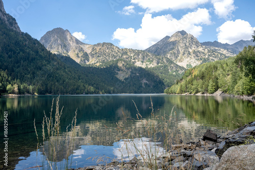 Mountain lake with forest and peaks reflected in calm water