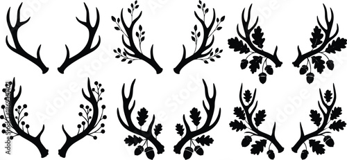 Monochrome vector art set of symmetrical animal antler silhouettes with leaves berries and acorns decorative elements for seasonal autumn and forest themed designs