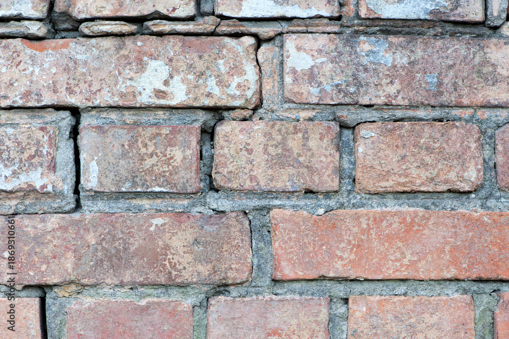 Obraz premium red old brick wall background, brick wall texture, structure. old broken brick, cement joints, close-up. crumbling from old age. macro photo. construction, repair. concept of devastation, decline