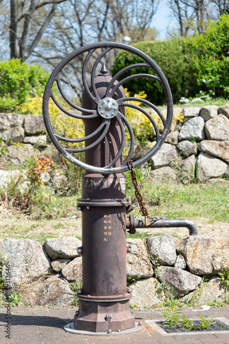 公園に設置された災害対策用の手押しポンプと錆びた鉄の質感（非常用井戸・飲用不可・雨水利用）