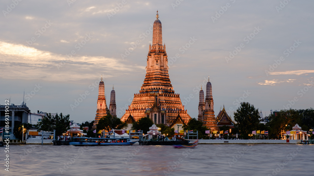 Fototapeta premium Stunning twilight view of Wat Arun temple along the Chao Phraya River in Bangkok, Thailand