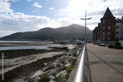 Seafront promenade walkway and pedestrian bridge with Mourne Mountains in Newcastle, County Down, Northern Ireland