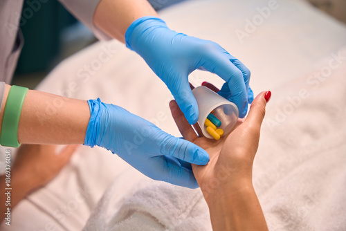 Cuadro en lienzo Nurse administering pills to patient resting in hospital bed
