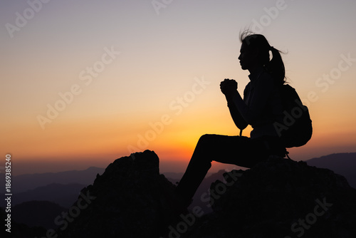 Schilderij op canvas Silhouette of prayer woman worship God in the morning with sunrise sky background
