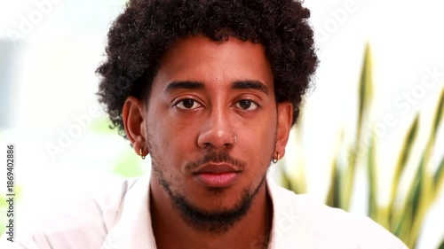 smiling portrait of a young latino man with afro hair