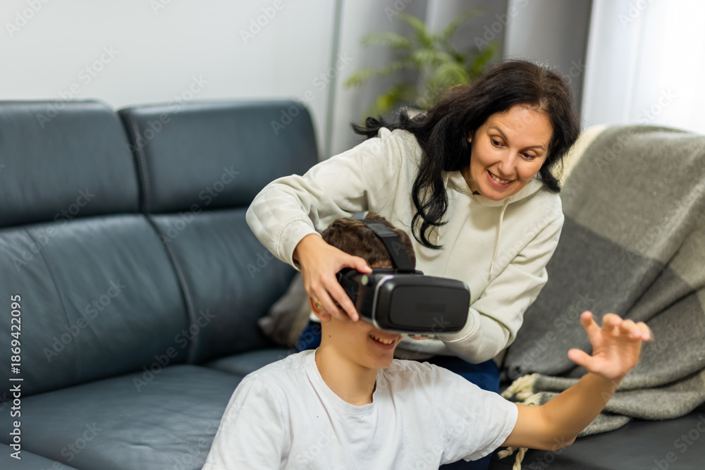 Obraz premium Mother Adjusting VR Headset for Her Son - Virtual Reality and Tech Education at Home