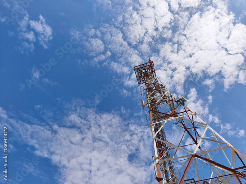 Telecom Cellular Antenna Tower with Blue Cloudy Sky