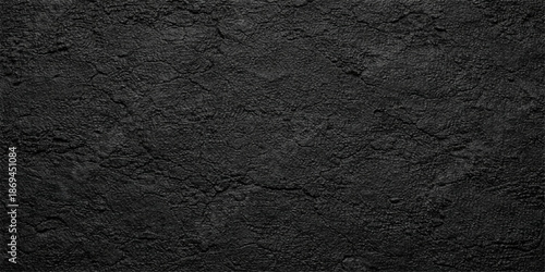 A dark, rough black leather and fabric texture with a grunge stone pattern on a gray concrete wall material creates an old, textured cement surface backdrop for a black and white background