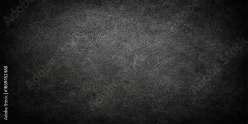 A dark and black grunge background features a textured grey concrete wall with an old vintage paper pattern on a rough dirty surface for a blank stone backdrop