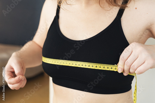 Woman measuring chest size with a measuring tape
