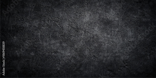 A dark black grunge concrete wall texture with a rough aged gray stone surface and dirty vintage paper pattern for a blank textured design backdrop