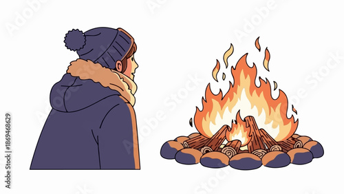Person in winter attire gazes at a crackling campfire