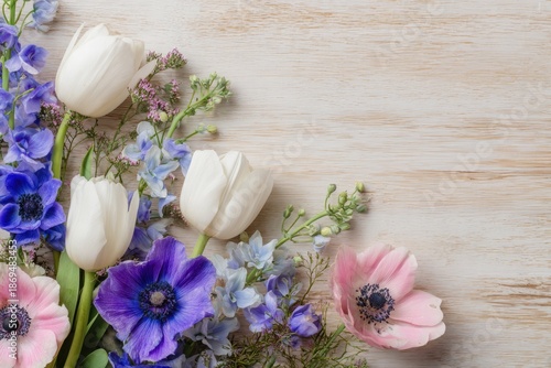 Spring Floral Arrangement with White Tulips and Blue Anemones on Wood