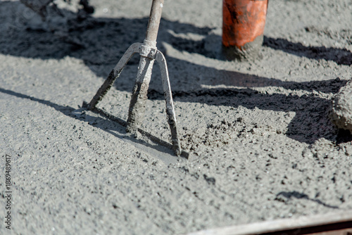Obraz na plátně Close-up of Builder uses spazzle to evenly level freshly mixed concrete on const