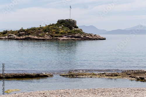 View of the pebble beach, the islet and the sea (Greece, Salamis Island)