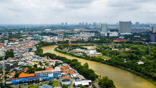 Foto Riverside landscape in Tangerang City, Banten, Indonesia with tranquil water and everyday urban life