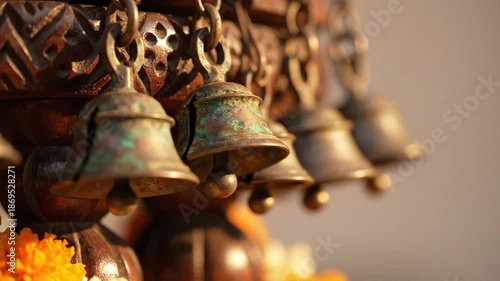 Decorative Antique Brass Bells With Intricate Carvings And Orange Marigolds Lit By Soft Golden Sunlight With A Textured Bokeh Background