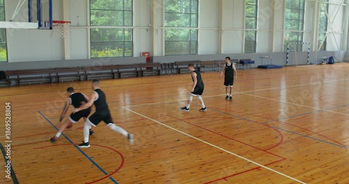 two-on-two basketball game. a team of four players play basketball on an indoor court.