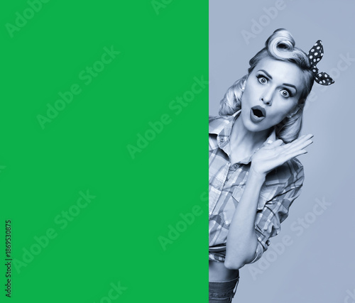 Expressive surprised woman with wide open eyes, moth. Pinup girl pointing showing green chroma key chromakey banner with free space, isolate gray background. Retro vintage ad image