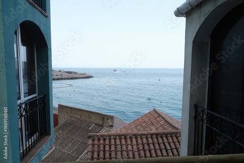 View of the mediterranean sea and marina from gibraltar, with a tiled rooftop in the foreground and boats in the water