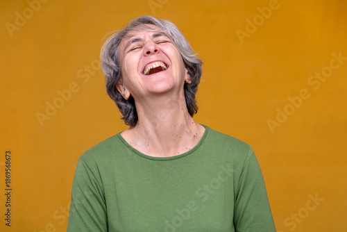 Fotografija Senior woman with gray hair experiencing joy, giggling and showing happiness on