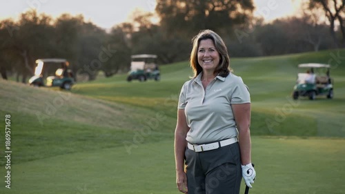 Senior woman plays golf at sunset on a green course with friends enjoying the evening outdoors