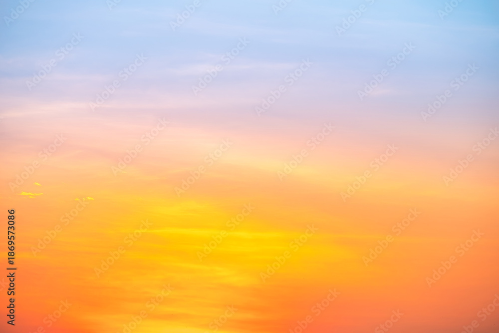 Fototapeta premium Sunset or sunrise sky with a vibrant gradient of orange, gold, and soft blue. Clear atmosphere with wispy clouds. Peaceful, natural light background. hope, freedom, new day and inspirational Concepts