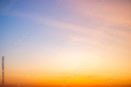 Fotografie Sunset or sunrise sky with a vibrant gradient of orange, gold, and soft blue