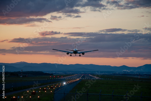 夕暮れの飛行場に着陸するジェット機
