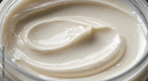 Creamy Swirl - Close-Up of Smooth, White Moisturizer in a Clear Jar, Luxurious Texture.