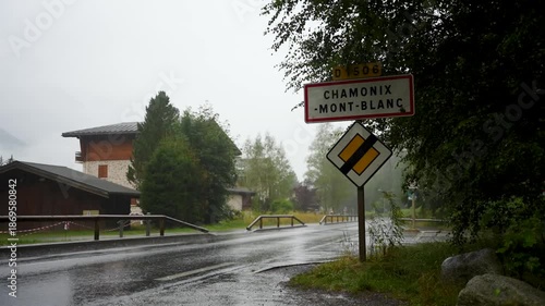 Ortsschild von Chamonix Mont Blanc in Frankreich im Regen. Auf der Straße davor fährt ein Auto vorbei.